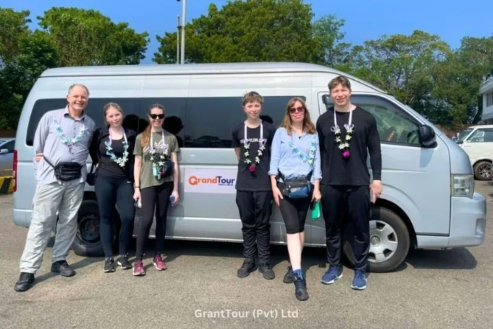A couple with their chauffeur guide beside the tour vehicle